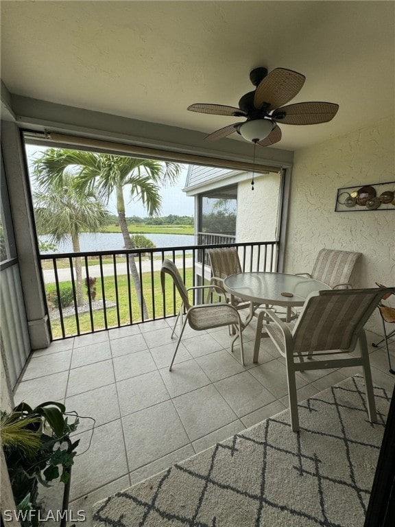 balcony with a water view and ceiling fan