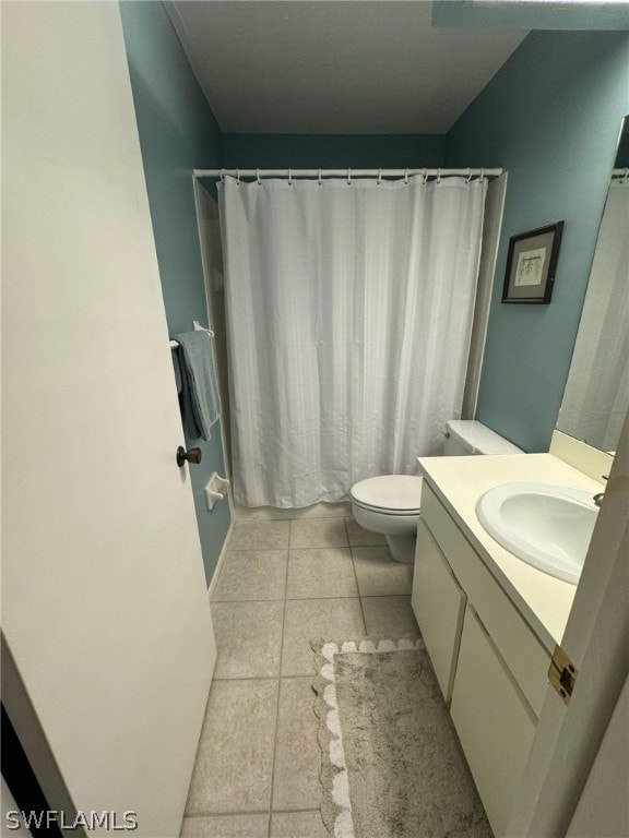 bathroom featuring tile flooring, toilet, and vanity