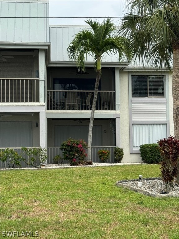 back of house featuring a yard and a balcony