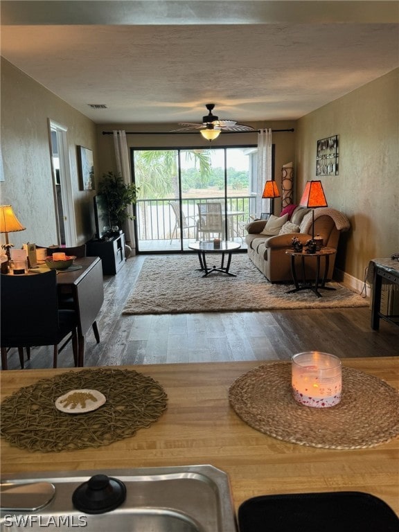 living room featuring ceiling fan and hardwood / wood-style floors