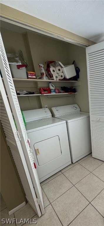 clothes washing area featuring independent washer and dryer and light tile flooring