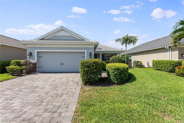 single story home featuring a garage, cooling unit, and a front lawn