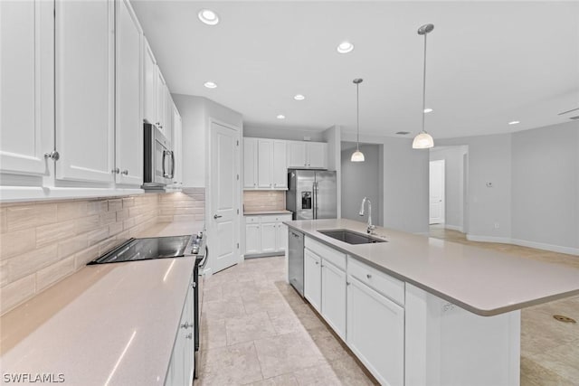 kitchen with pendant lighting, sink, a kitchen island with sink, stainless steel appliances, and white cabinets