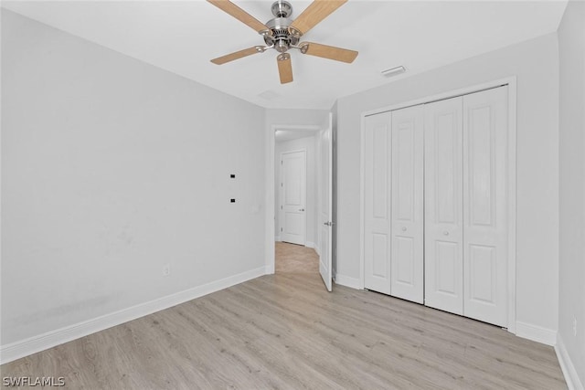 unfurnished bedroom featuring ceiling fan, a closet, and light wood-type flooring