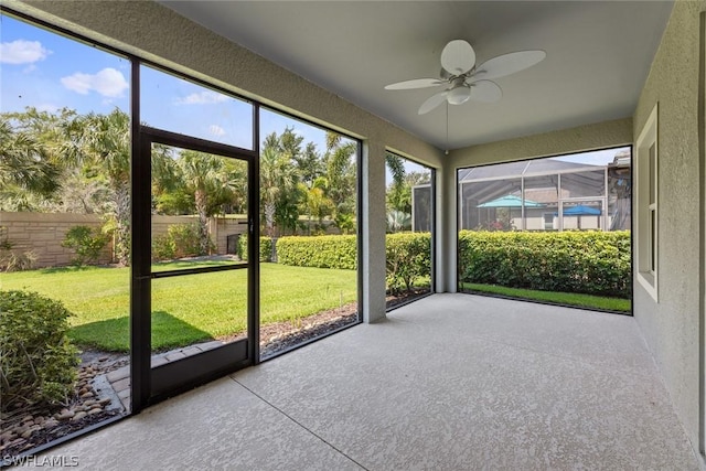 unfurnished sunroom with ceiling fan