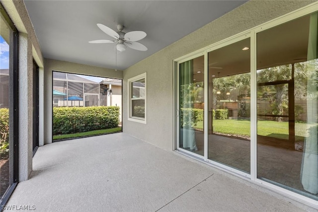 unfurnished sunroom with ceiling fan