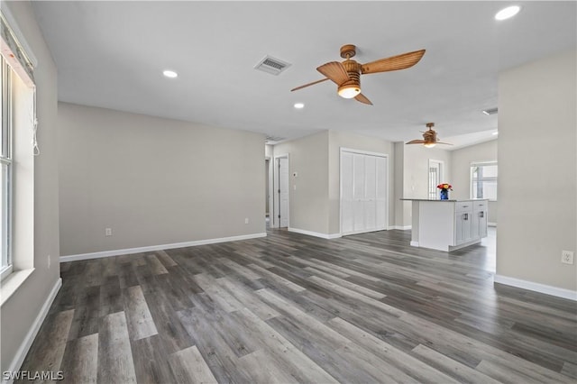 unfurnished living room with dark wood-style floors, recessed lighting, visible vents, ceiling fan, and baseboards