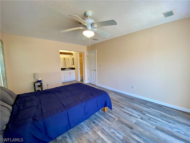 bedroom featuring a textured ceiling, wood-type flooring, and ceiling fan