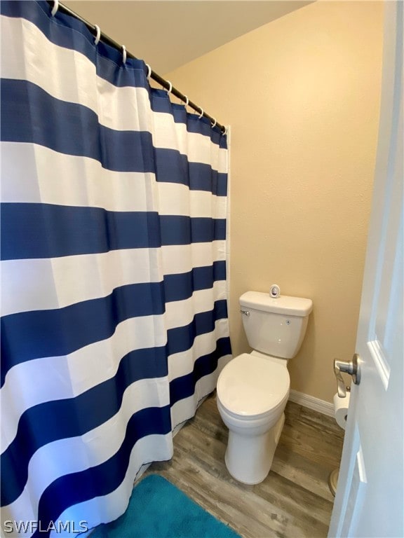 bathroom featuring wood-type flooring and toilet