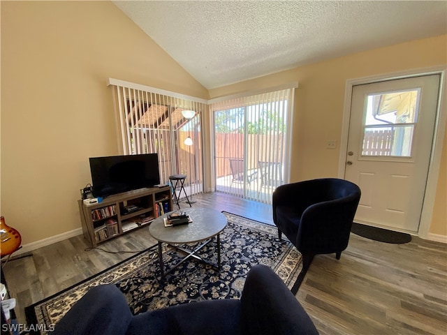 living room featuring lofted ceiling, a textured ceiling, and hardwood / wood-style flooring