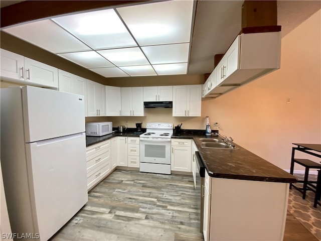 kitchen with white appliances, white cabinets, sink, and hardwood / wood-style floors