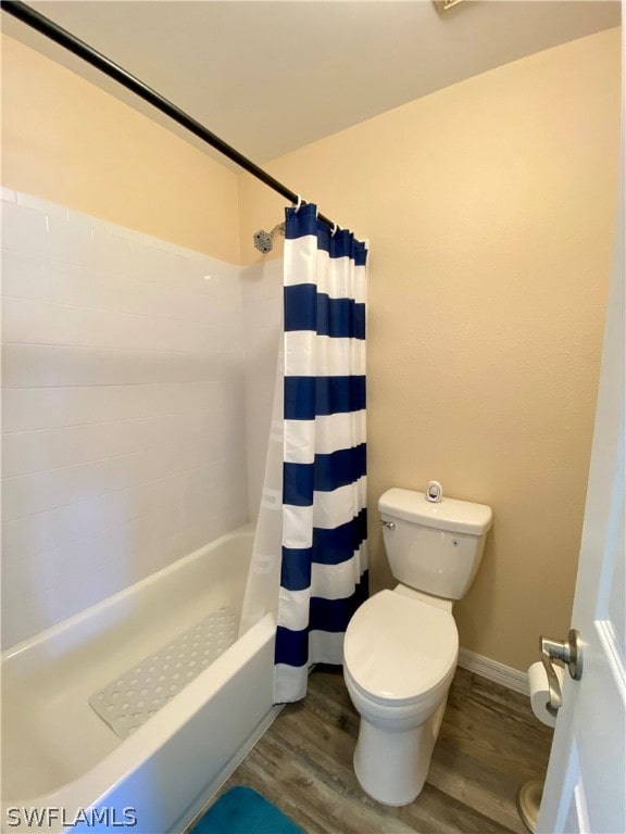 bathroom featuring hardwood / wood-style flooring, toilet, and shower / tub combo