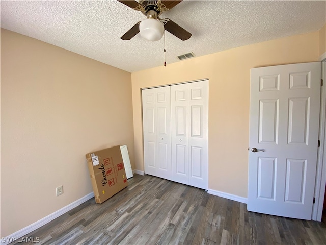 unfurnished bedroom featuring a textured ceiling, dark hardwood / wood-style floors, a closet, and ceiling fan