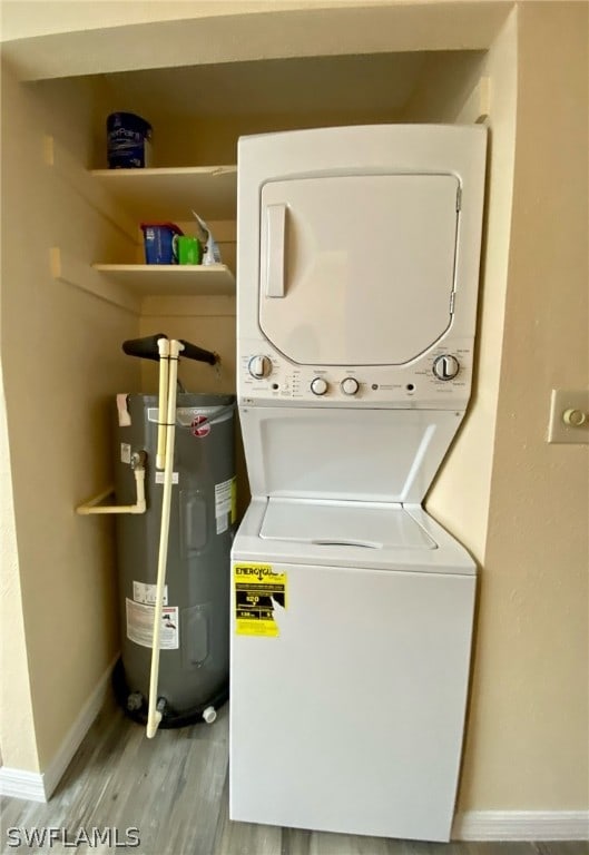 laundry room featuring water heater, hardwood / wood-style flooring, and stacked washer and dryer