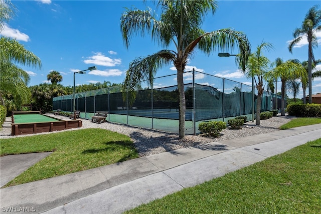 view of sport court featuring a lawn