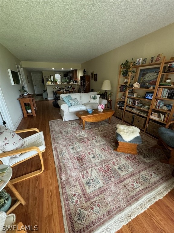 living room with wood-type flooring and a textured ceiling