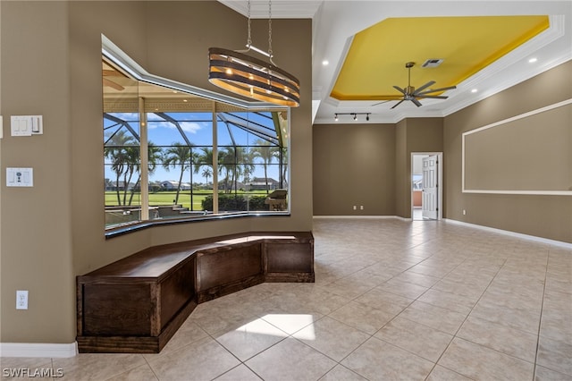 interior space featuring tile patterned flooring, ceiling fan with notable chandelier, ornamental molding, and a tray ceiling