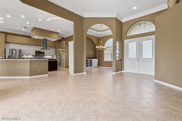 interior space featuring light tile patterned flooring, french doors, crown molding, and an inviting chandelier