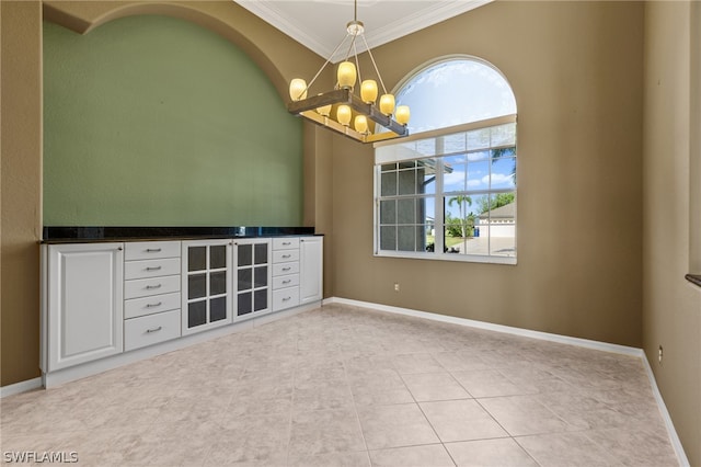 unfurnished room with crown molding, light tile patterned flooring, and a chandelier