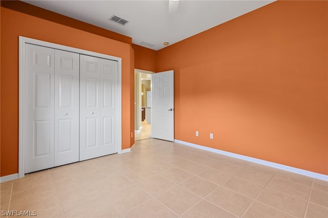 unfurnished bedroom featuring light tile patterned floors, a closet, and ceiling fan