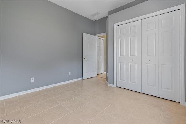 unfurnished bedroom featuring light tile patterned floors and a closet