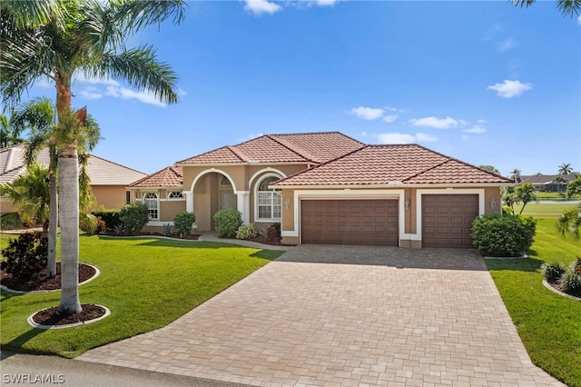 mediterranean / spanish-style home featuring a garage and a front lawn