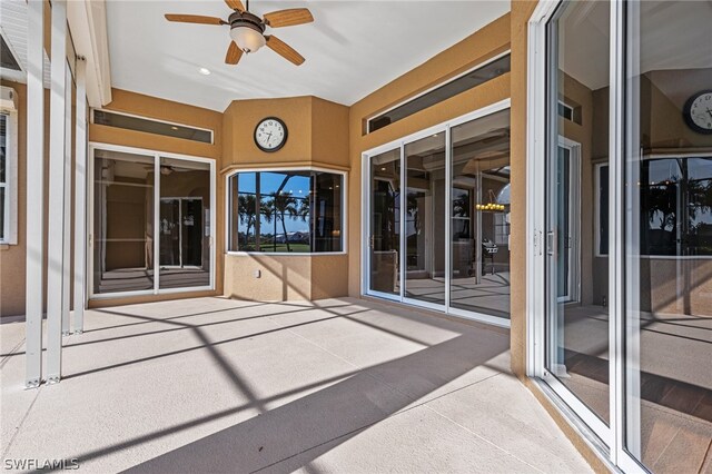 unfurnished sunroom featuring ceiling fan