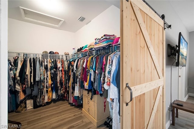 spacious closet with hardwood / wood-style flooring and a barn door