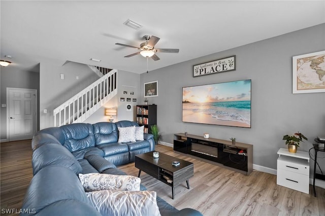 living room featuring ceiling fan and light hardwood / wood-style flooring