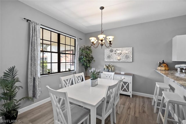 dining room featuring dark hardwood / wood-style floors and an inviting chandelier