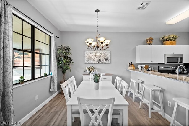 dining room featuring light hardwood / wood-style floors and an inviting chandelier