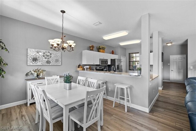 dining room with a chandelier and light wood-type flooring