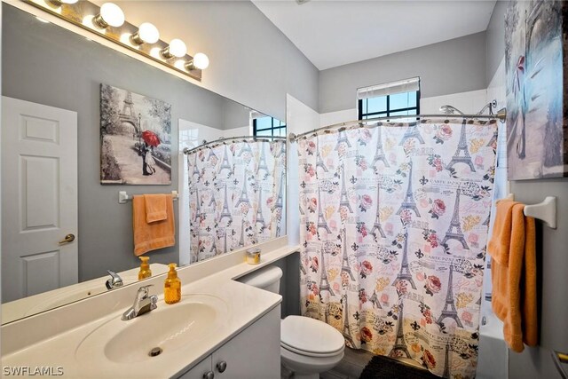 full bathroom with vanity, shower / tub combo, and toilet