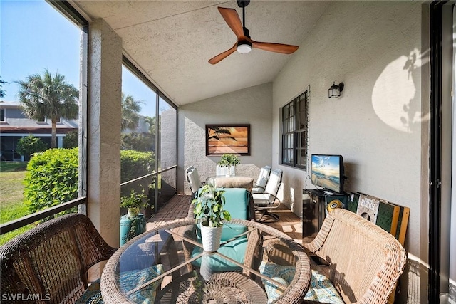 sunroom featuring vaulted ceiling, plenty of natural light, and ceiling fan