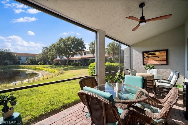 sunroom / solarium featuring ceiling fan, a water view, and lofted ceiling