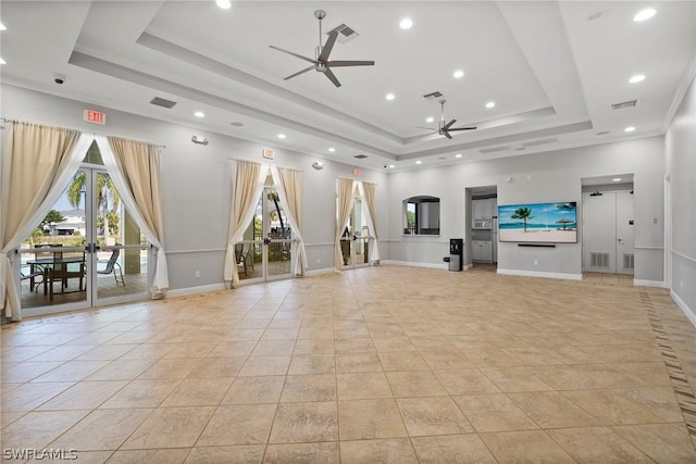 unfurnished living room with light tile patterned floors, a tray ceiling, and ceiling fan