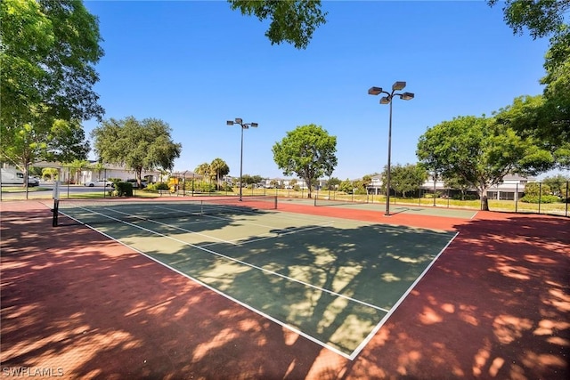 view of tennis court featuring basketball hoop