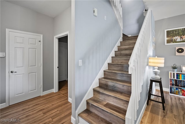 staircase with hardwood / wood-style floors