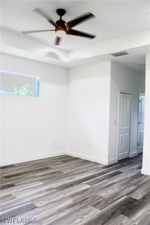 empty room with dark hardwood / wood-style floors and ceiling fan