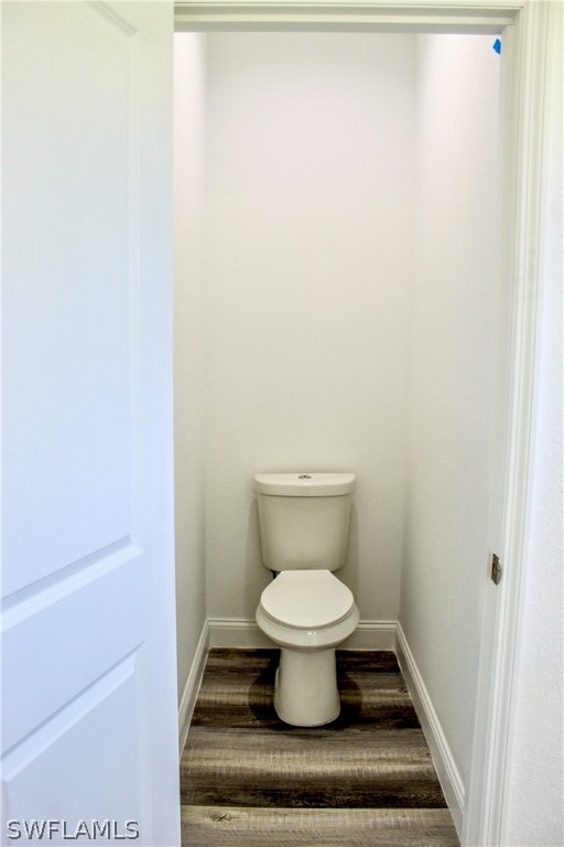 bathroom with toilet and wood-type flooring