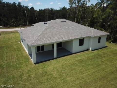 back of property featuring a lawn and a patio