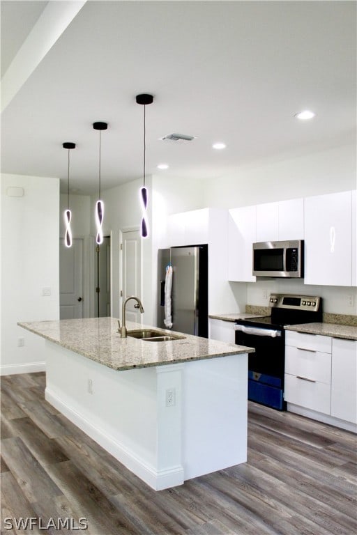 kitchen with an island with sink, stainless steel appliances, dark hardwood / wood-style flooring, and white cabinets