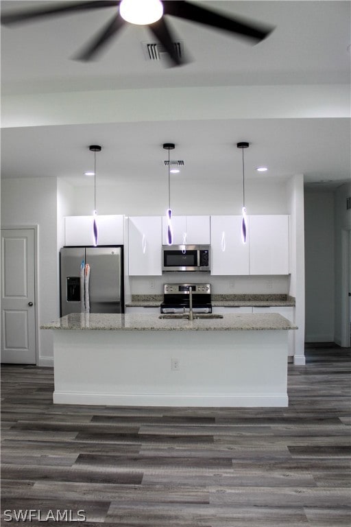 kitchen featuring ceiling fan, white cabinets, a kitchen island with sink, and appliances with stainless steel finishes