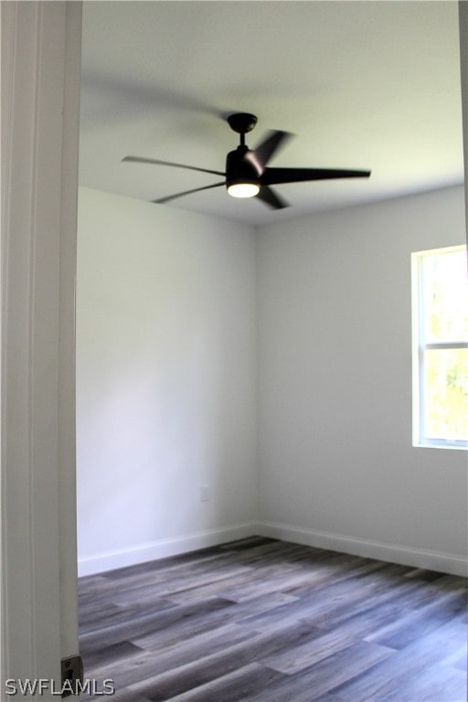 unfurnished room with ceiling fan and dark wood-type flooring