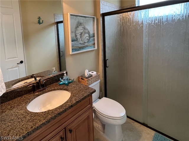 bathroom with tile patterned flooring, vanity, toilet, and a shower with shower door