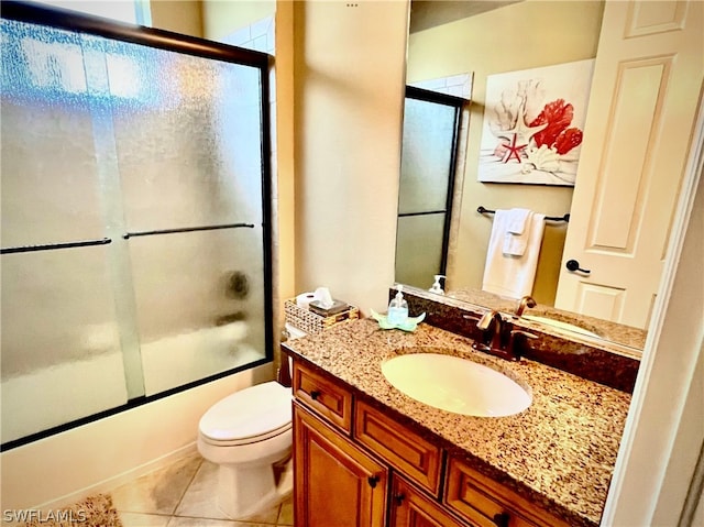 full bathroom with tile patterned floors, vanity, toilet, and bath / shower combo with glass door