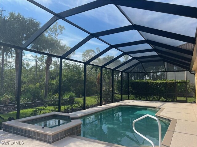 view of swimming pool featuring a patio area, a lanai, and an in ground hot tub