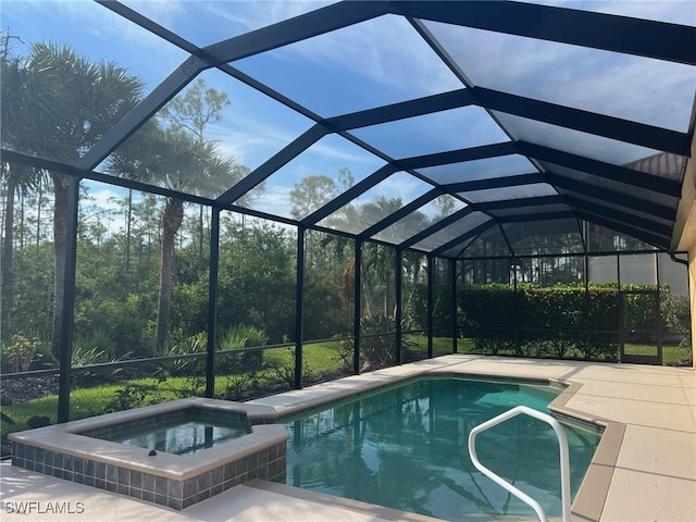 view of swimming pool featuring glass enclosure, a patio area, and a pool with connected hot tub