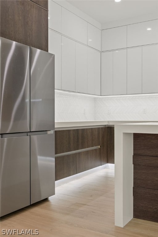 interior space featuring white cabinets, stainless steel fridge, and light hardwood / wood-style floors