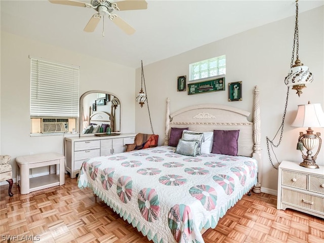 bedroom with cooling unit, ceiling fan, and light parquet flooring